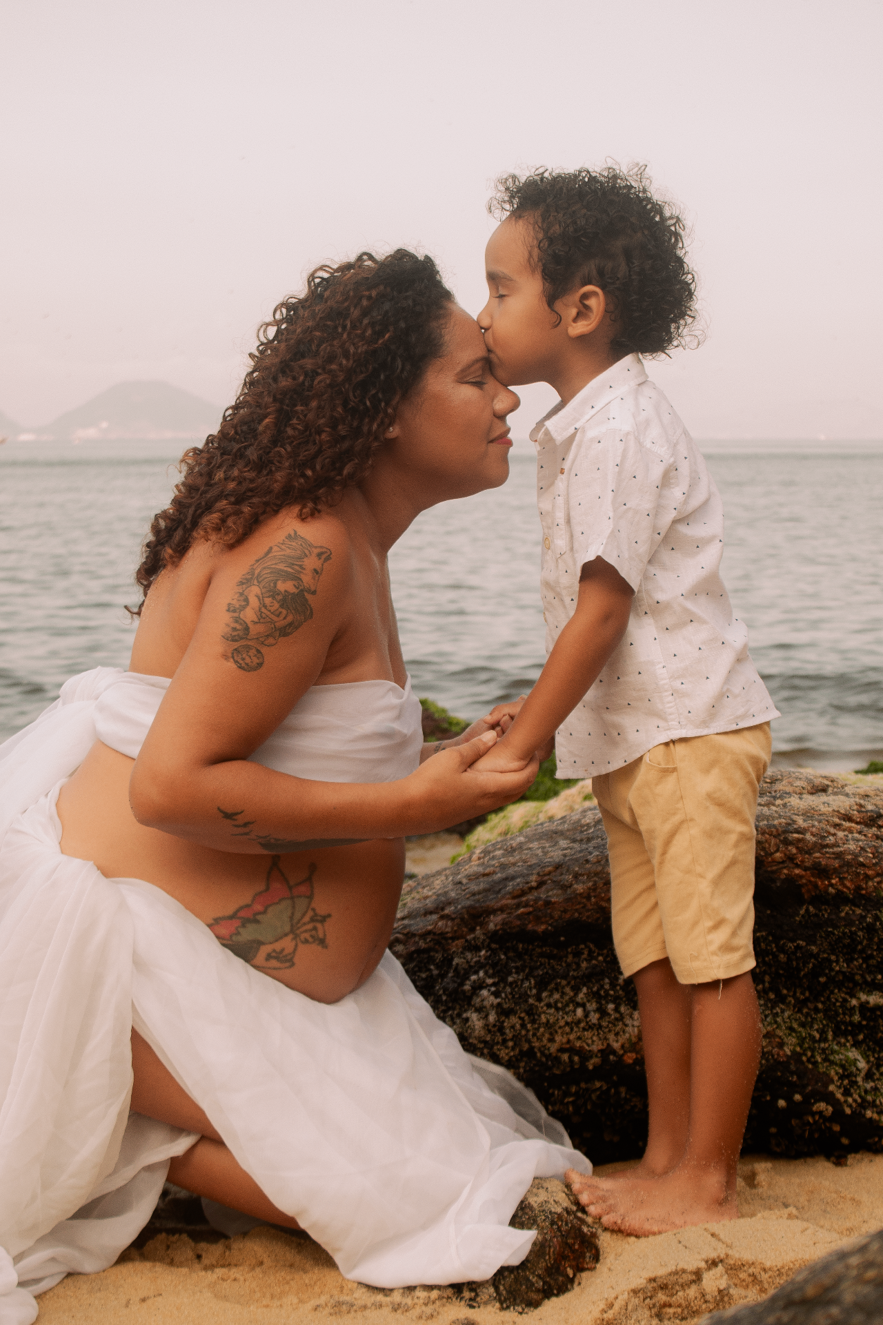 Mãe grávida e filho em ensaio autoral na praia